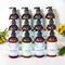 Twelve bottles of luxurious lotions by Whole Self Aromatherapy atop a soft white table linen with yellow flowers on either side.